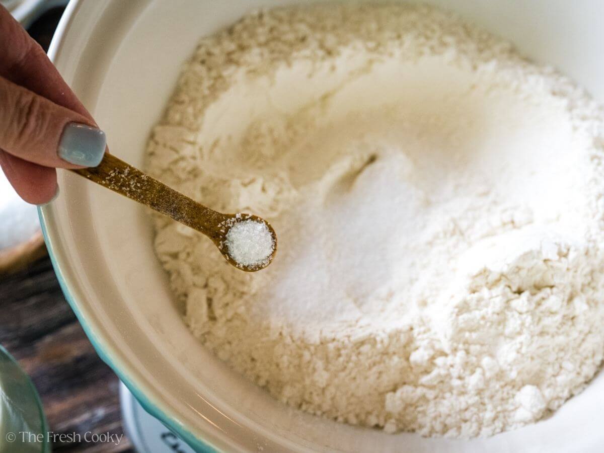 Adding salt to the dry ingredients.