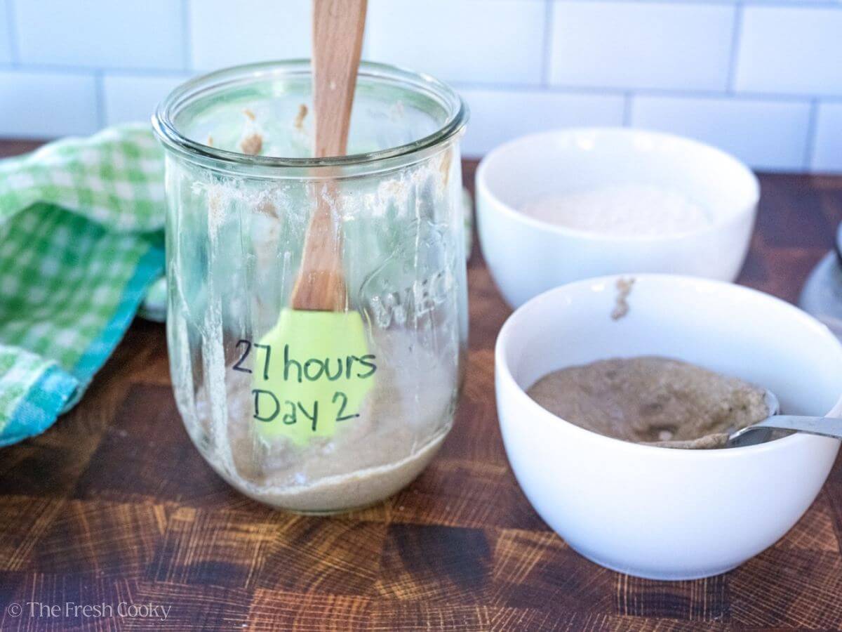Sourdough starter from the jar labeled "27 hours" poured into a bowl.