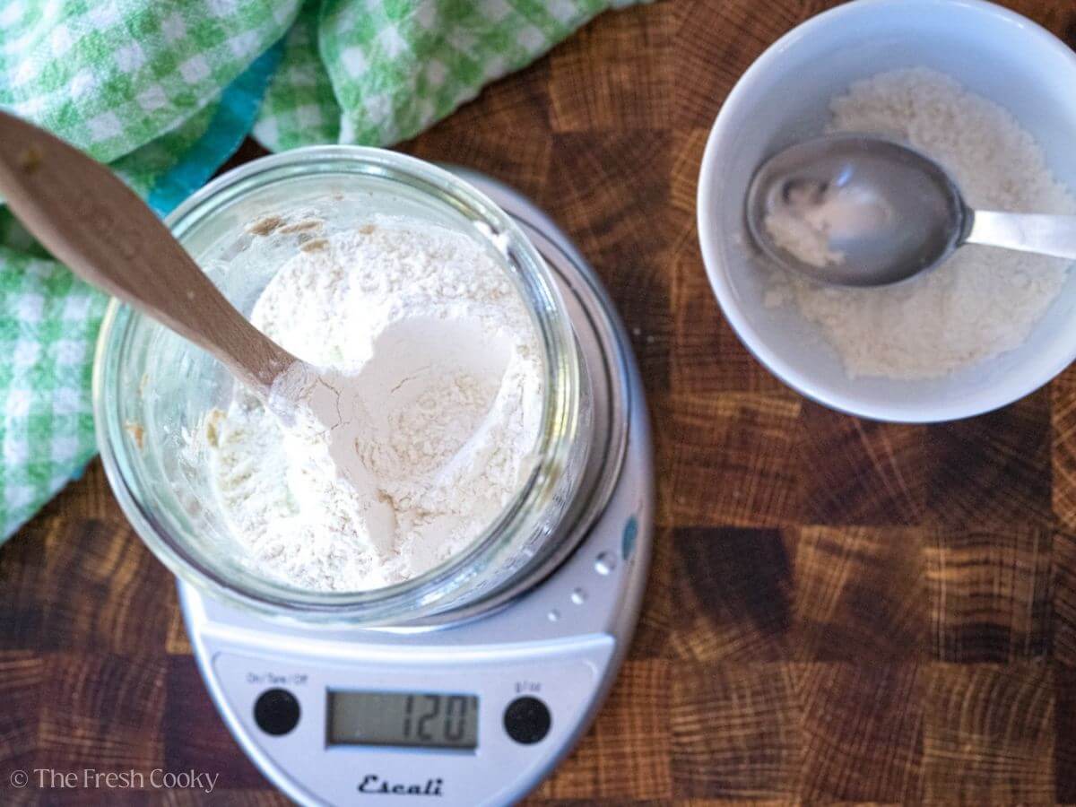 Measuring out the flour into a glass jar for the sourdough starter.