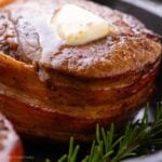 Close up shot of bacon wrapped filet mignon with a piece of butter melting on the top.