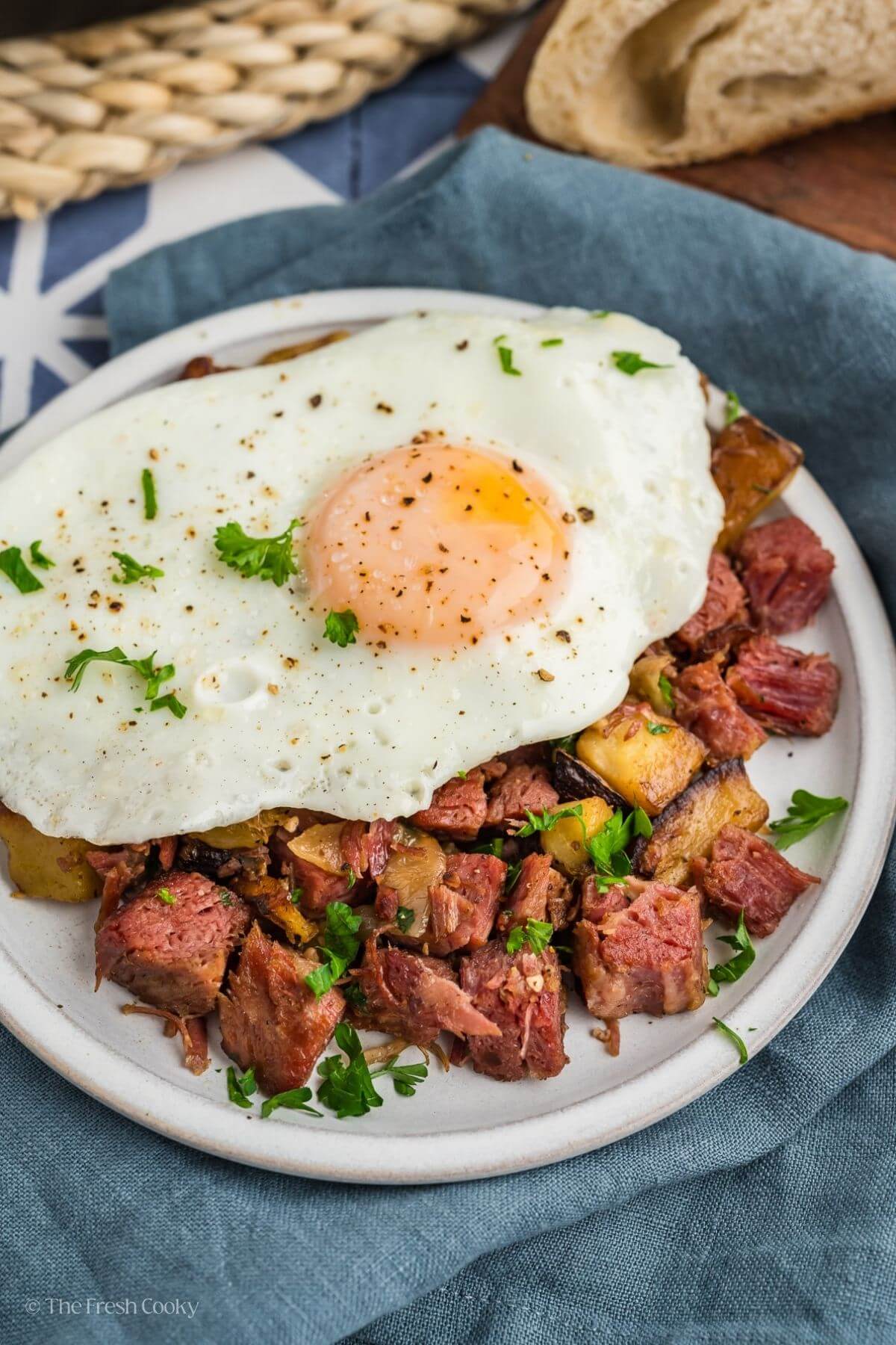 Corned beef hash on plate topped with fried egg. 