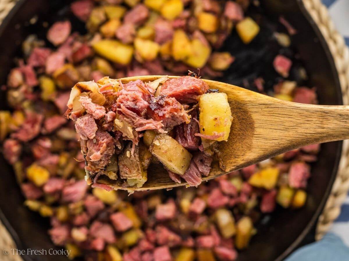 Corned beef hash with serving on a spoon.