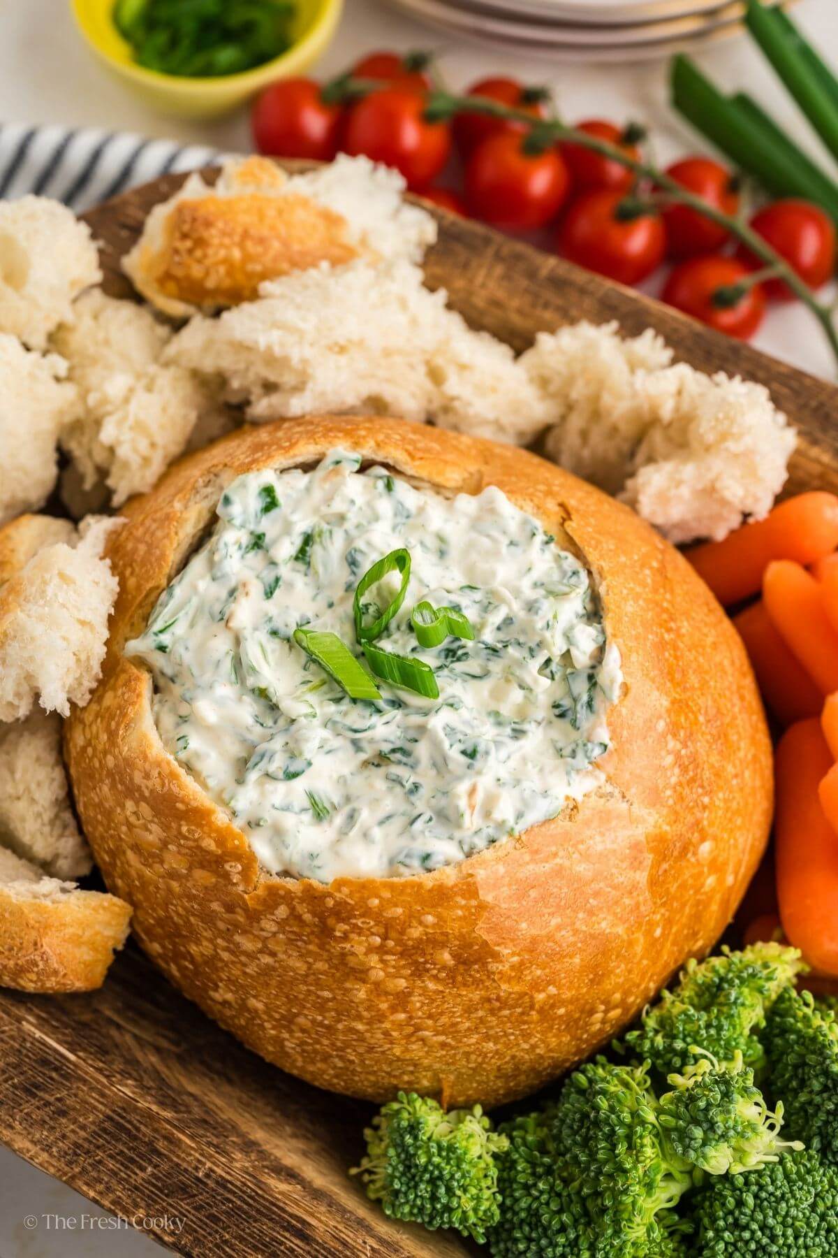 Knorr spinach dip in a bread bowl served with pieces of bread and veggies.