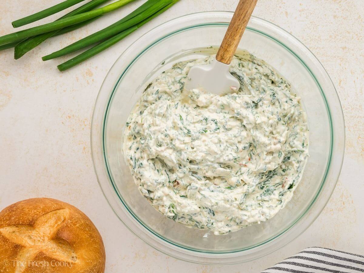 The mixed Knorr spinach dip in a glass bowl.