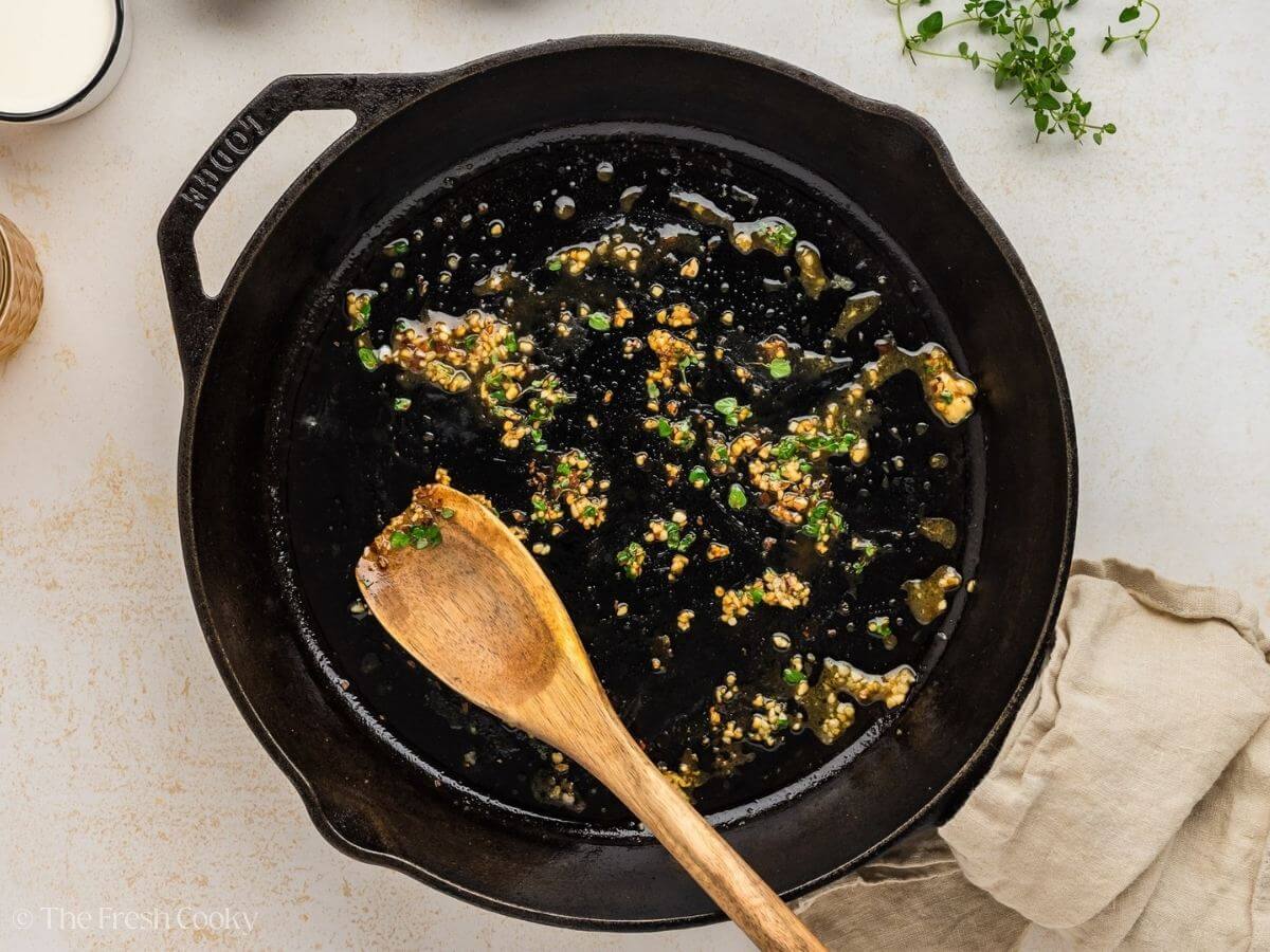 Cooking the garlic, thyme and red pepper flakes in a cast iron skillet.