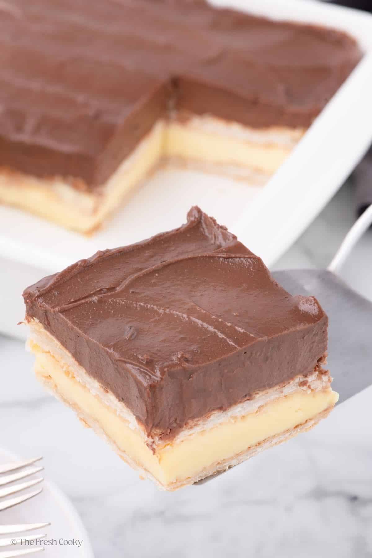 Slice of chocolate eclair cake on a spatula. 