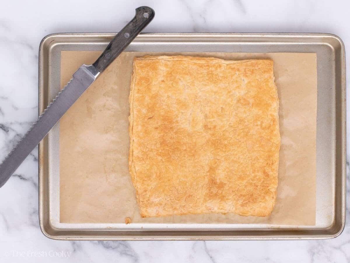 Baked puff pastry sheet on a sheet pan.