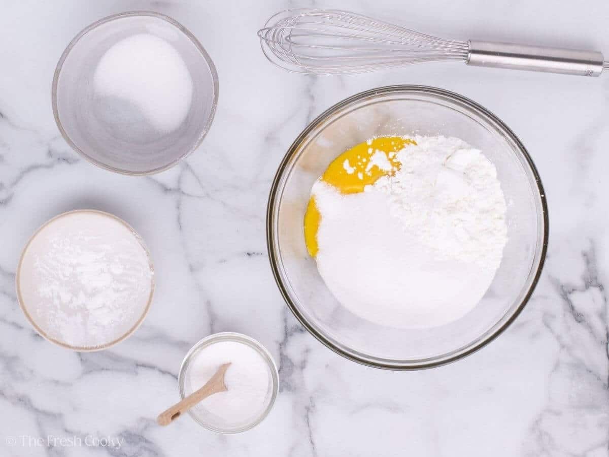 Cornstarch, sugar and salt added to egg yolks in a glass mixing bowl.