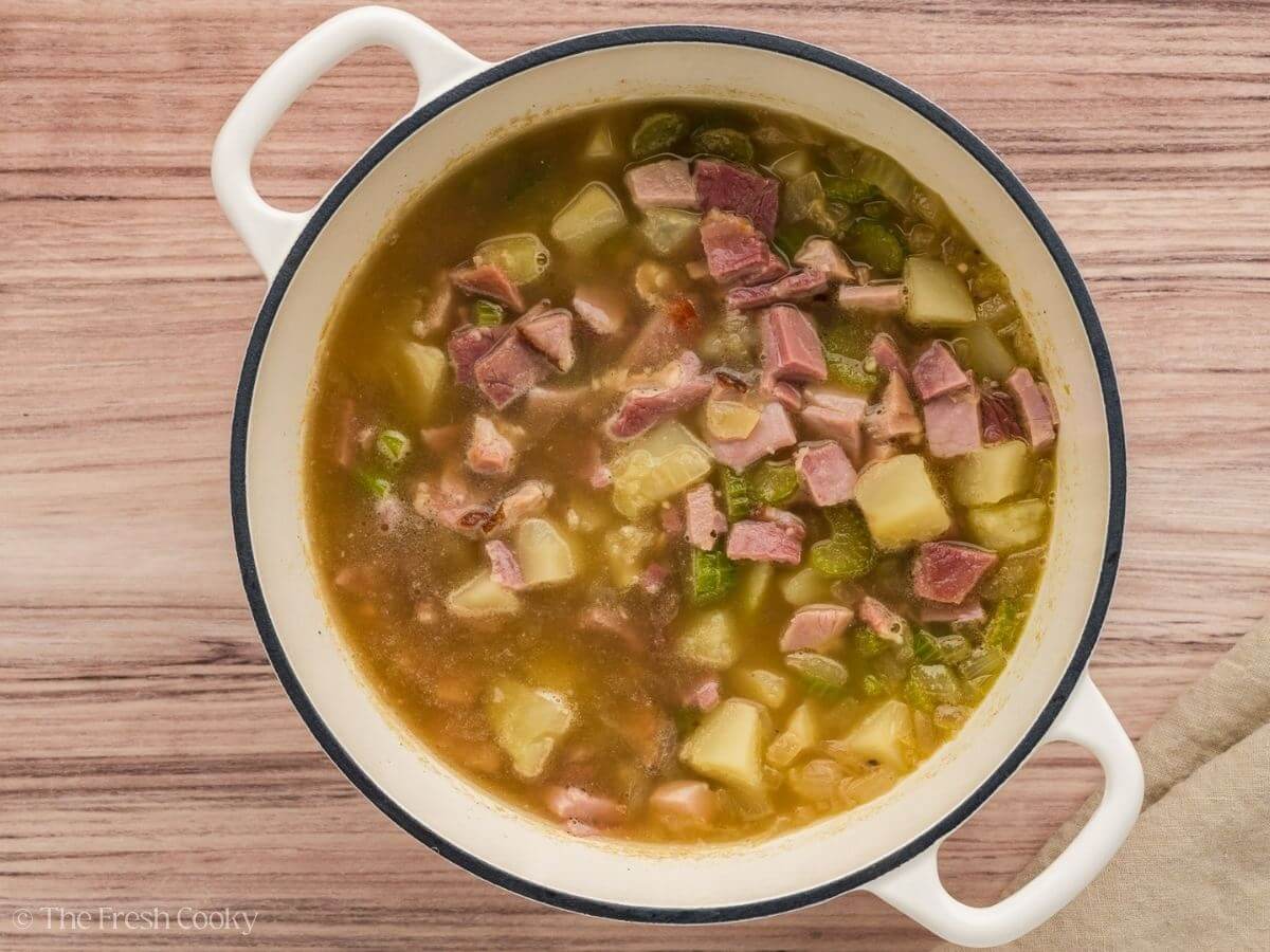 Diced ham added to the soup in a large stock pot.