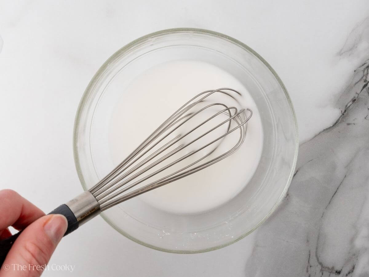 Making a cornstarch slurry in a bowl. 