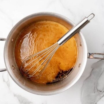 Whisking cornstarch slurry into saucepan.