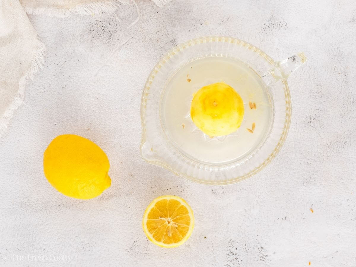Juicing lemons in a lemon juicer.