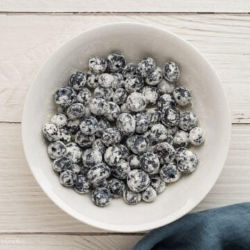 Fresh blueberries coated in flour in a bowl.