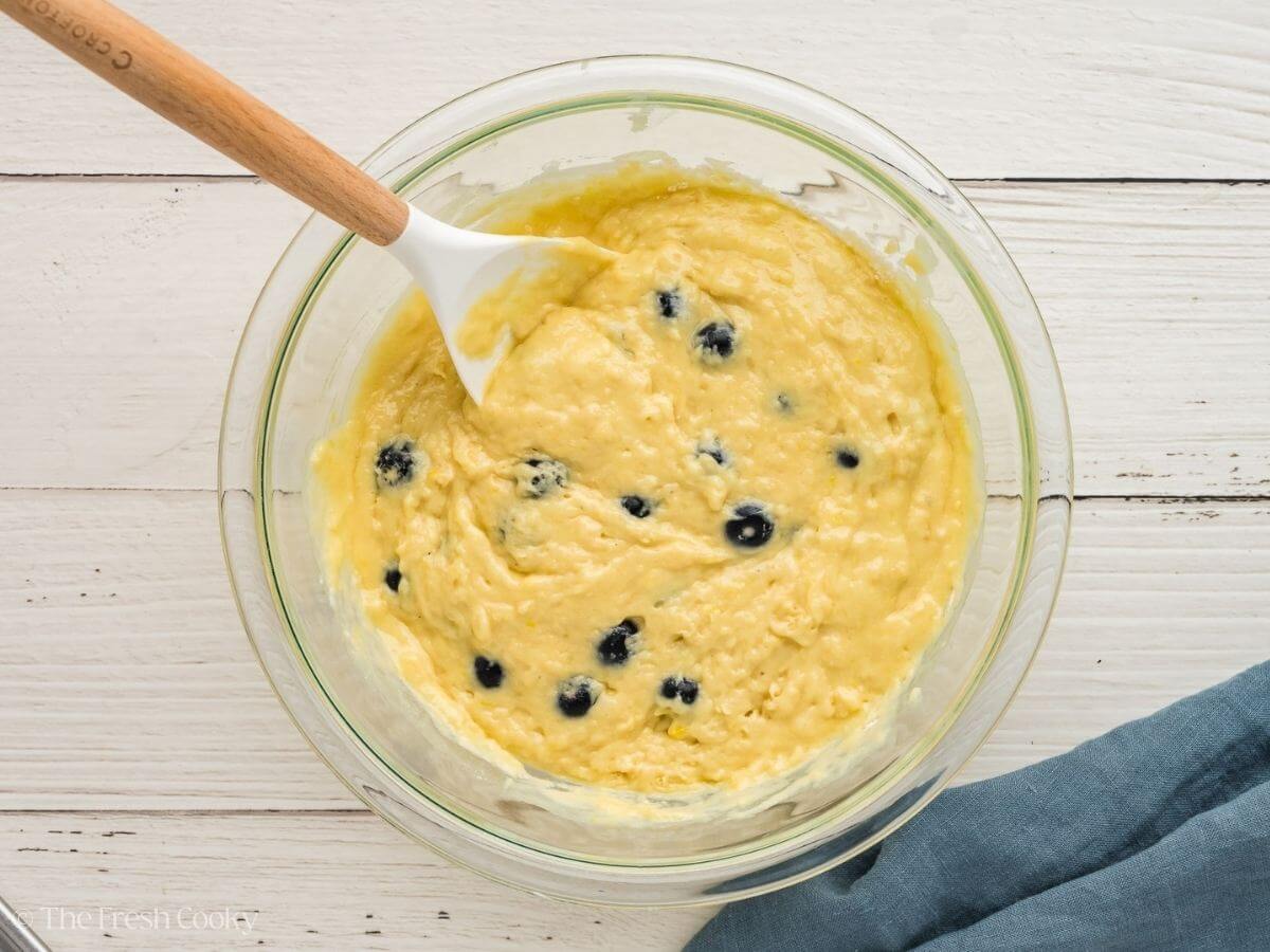 Lemon blueberry bread batter in a glass mixing bowl after mixing.
