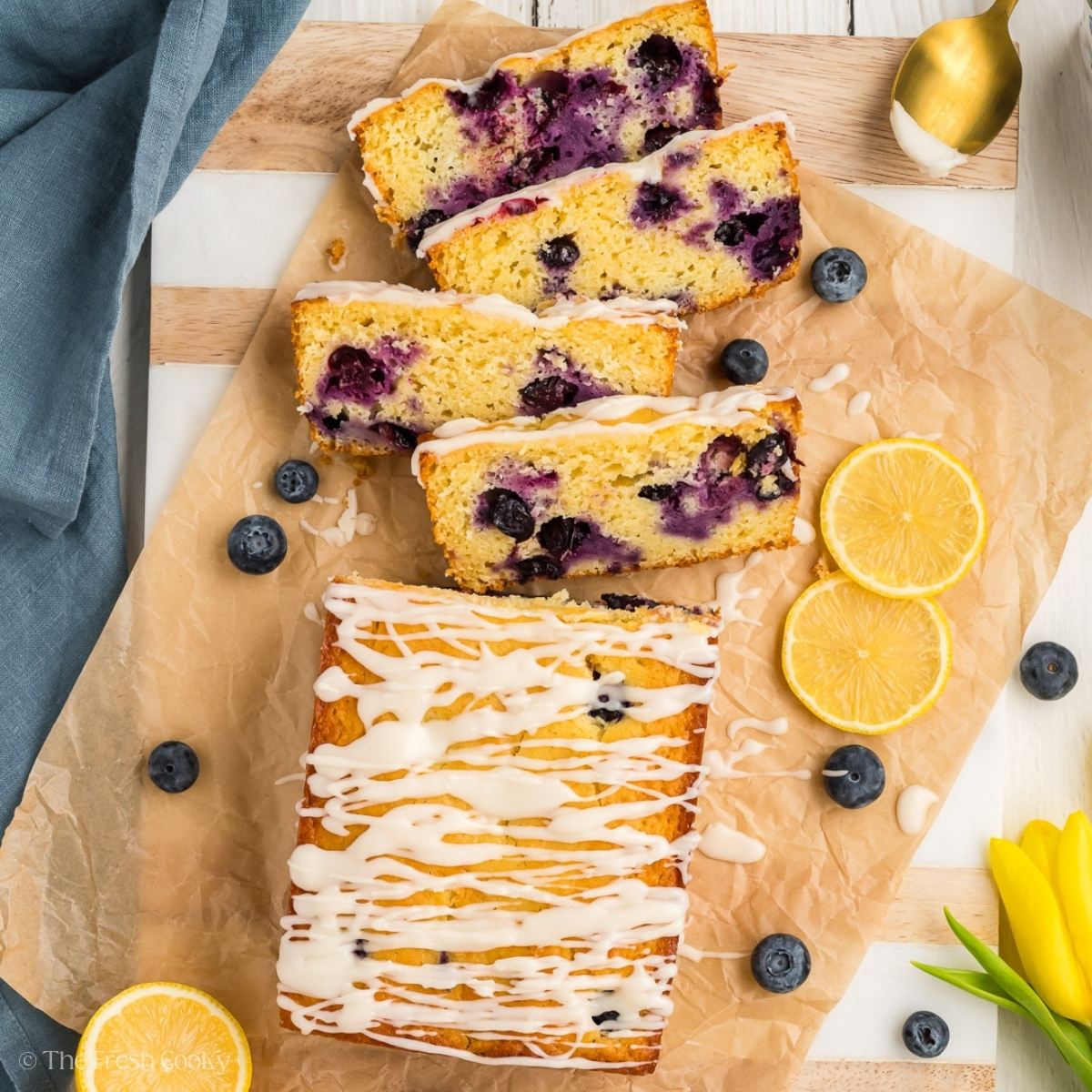 Slices of lemon blueberry bread on parchment.