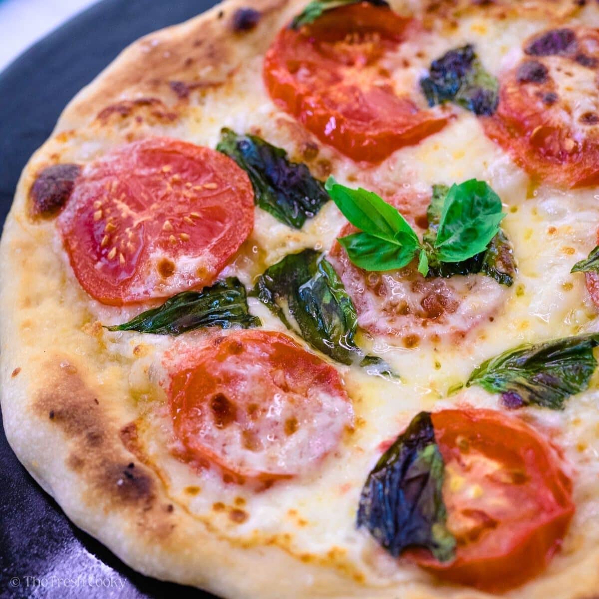 Margherita pizza on a pizza stone.