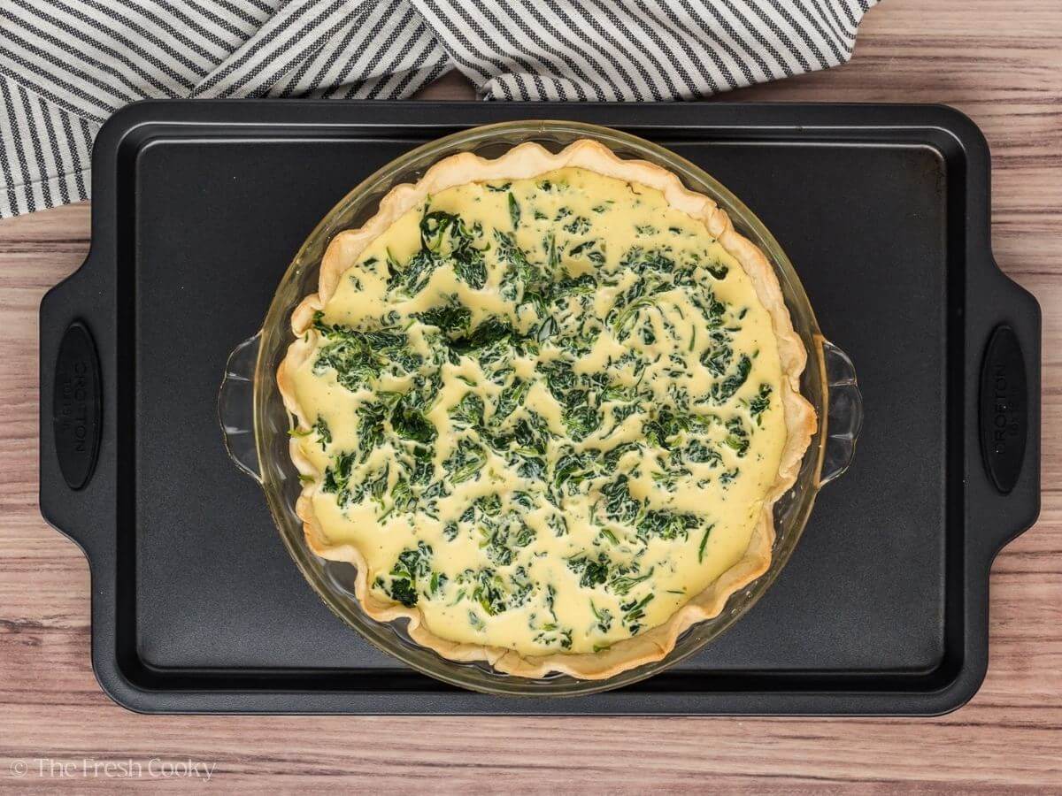 Whisked egg mixture poured on top of the spinach layer in a baked pie crust.