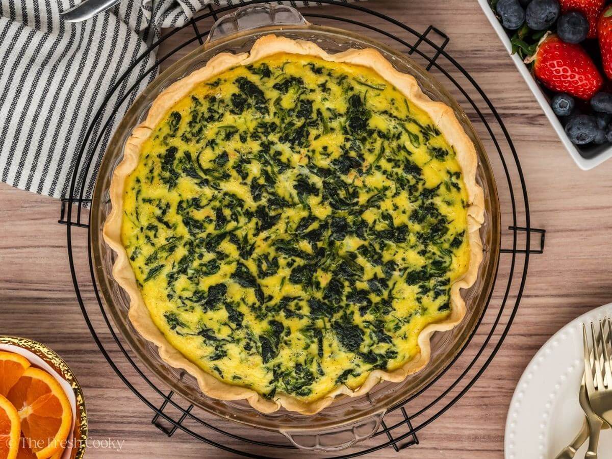 Overhead shot of spinach quiche in a pie pan after being baked.
