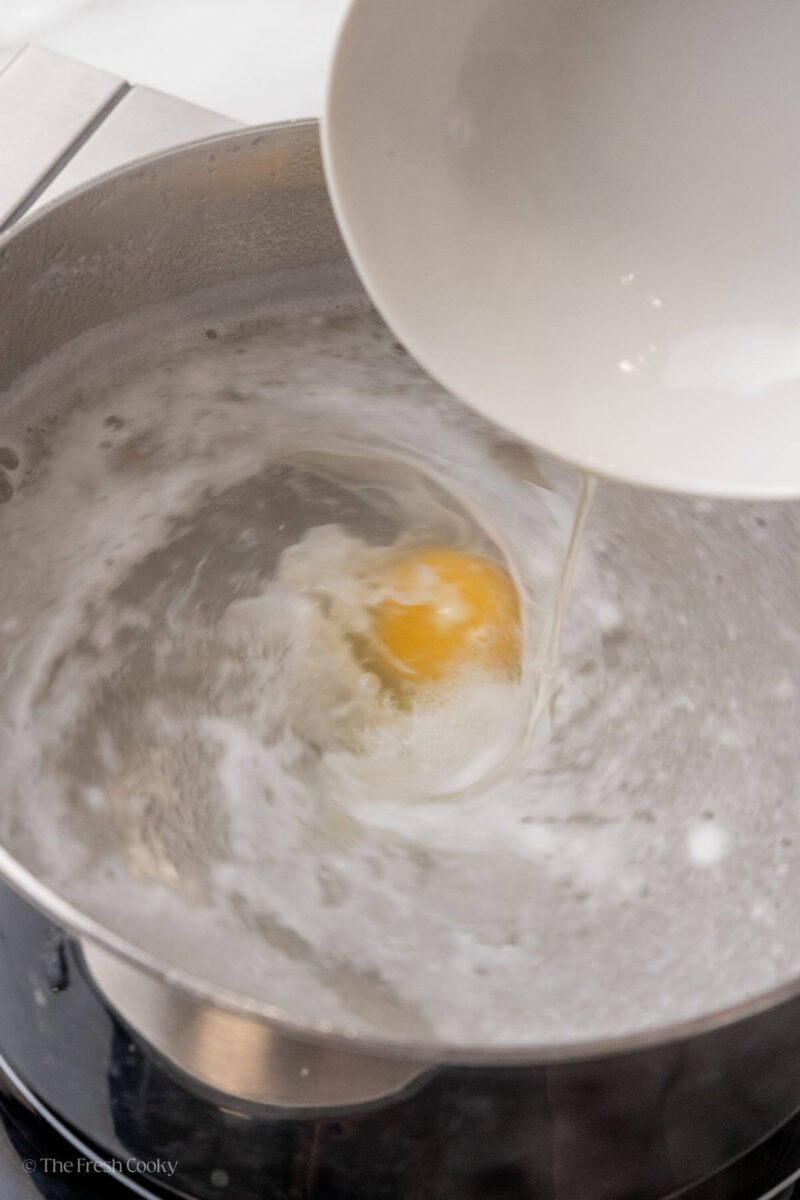 Pouring the egg into the boiling water to cook.