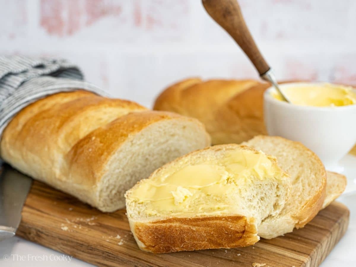Sliced pieces of french bread, buttered with bite taken out. 