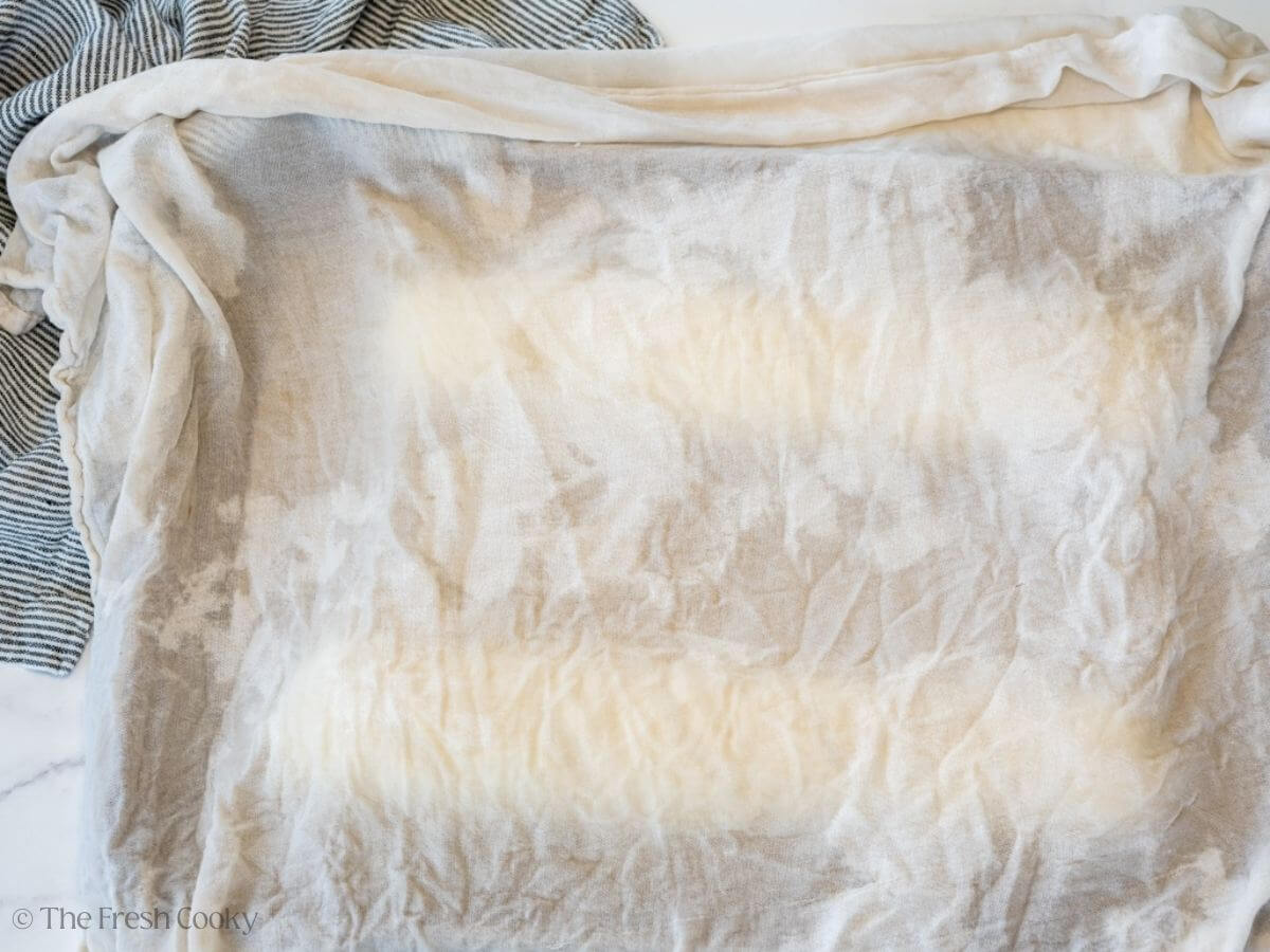 A cheese cloth placed over the bread dough to rise again before baking.