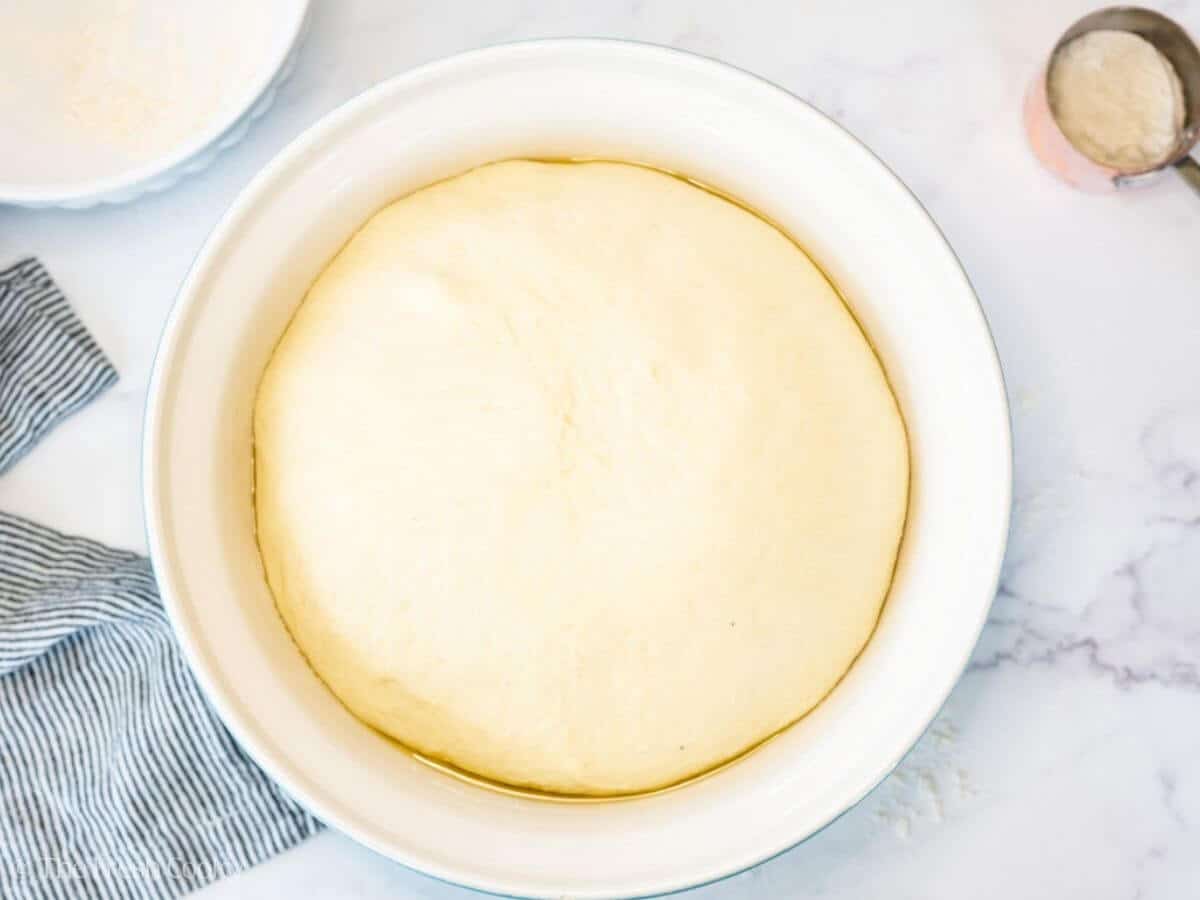 French bread dough in a large mixing bowl after rising.