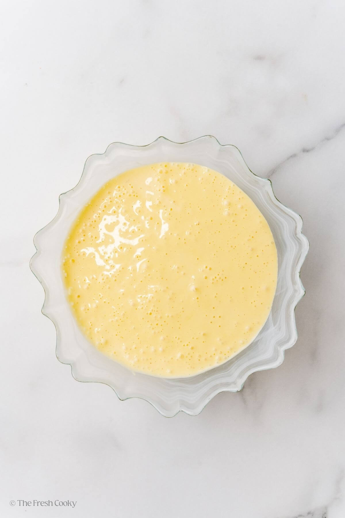 Overhead shot of hollandaise sauce in a glass dish.