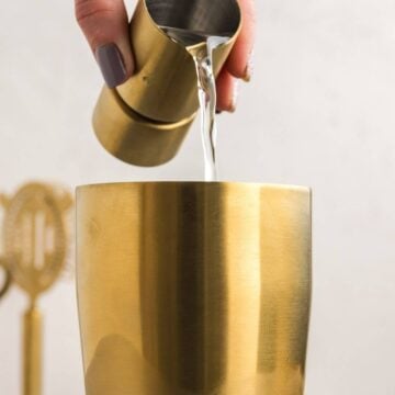 Pouring tequila into a cocktail shaker.