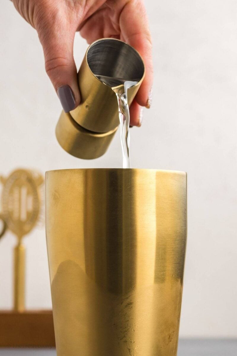 Pouring tequila into a cocktail shaker.