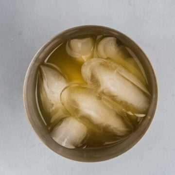 Overhead shot of skinny margarita ingredients and ice in a cocktail shaker.