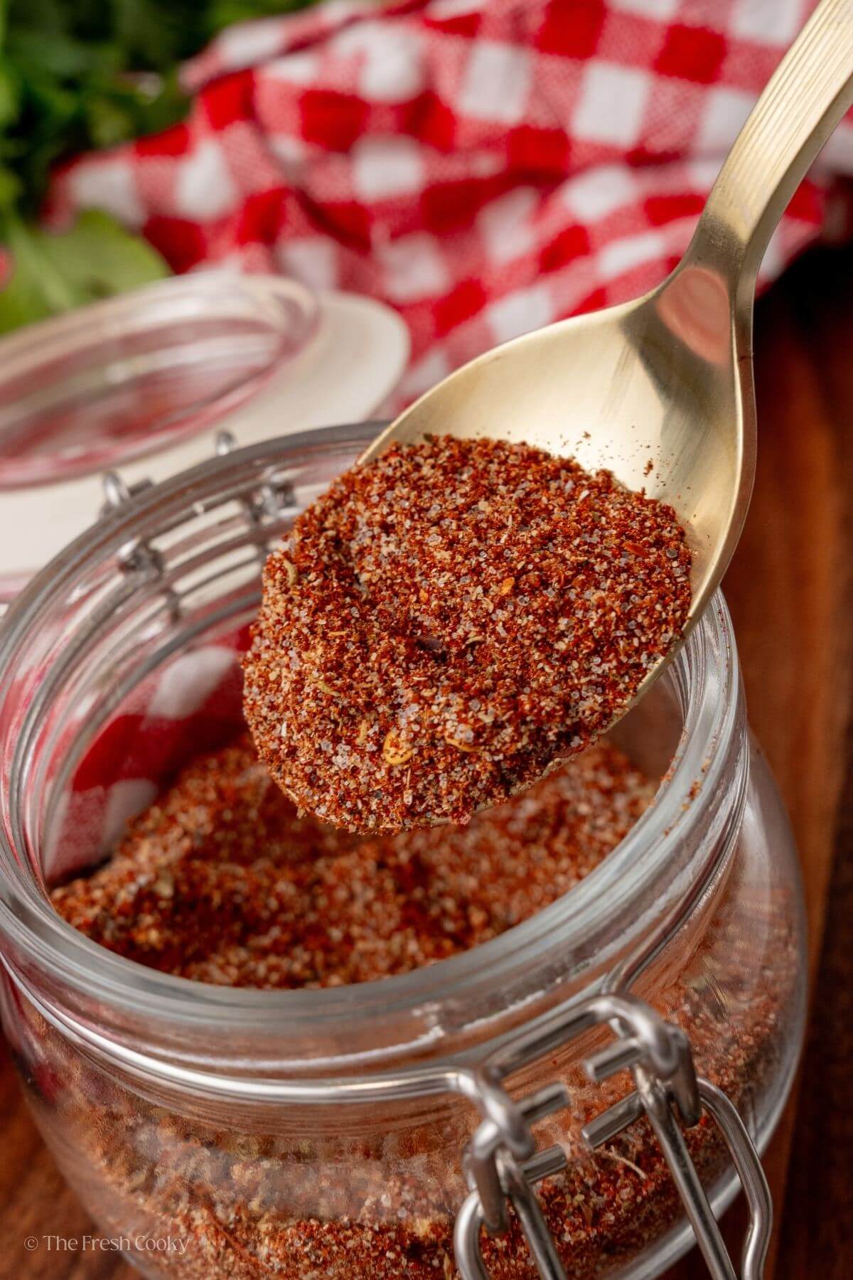 Spoon scooping up some of the taco seasoning from a jar.