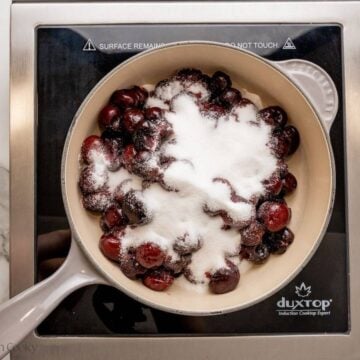 Sugar added to the cherry mixture in a skillet.