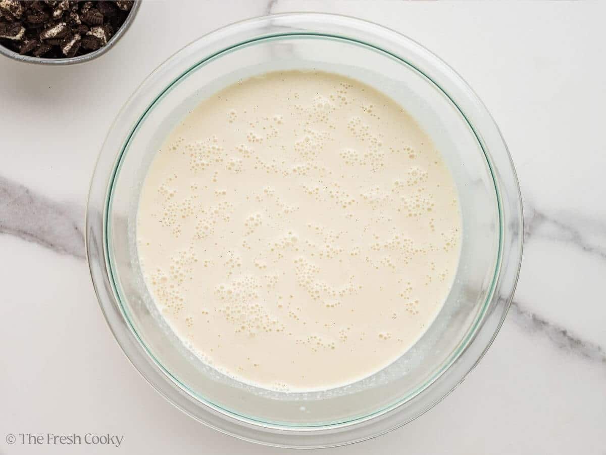 Cream added to the sugar mixture in a bowl.
