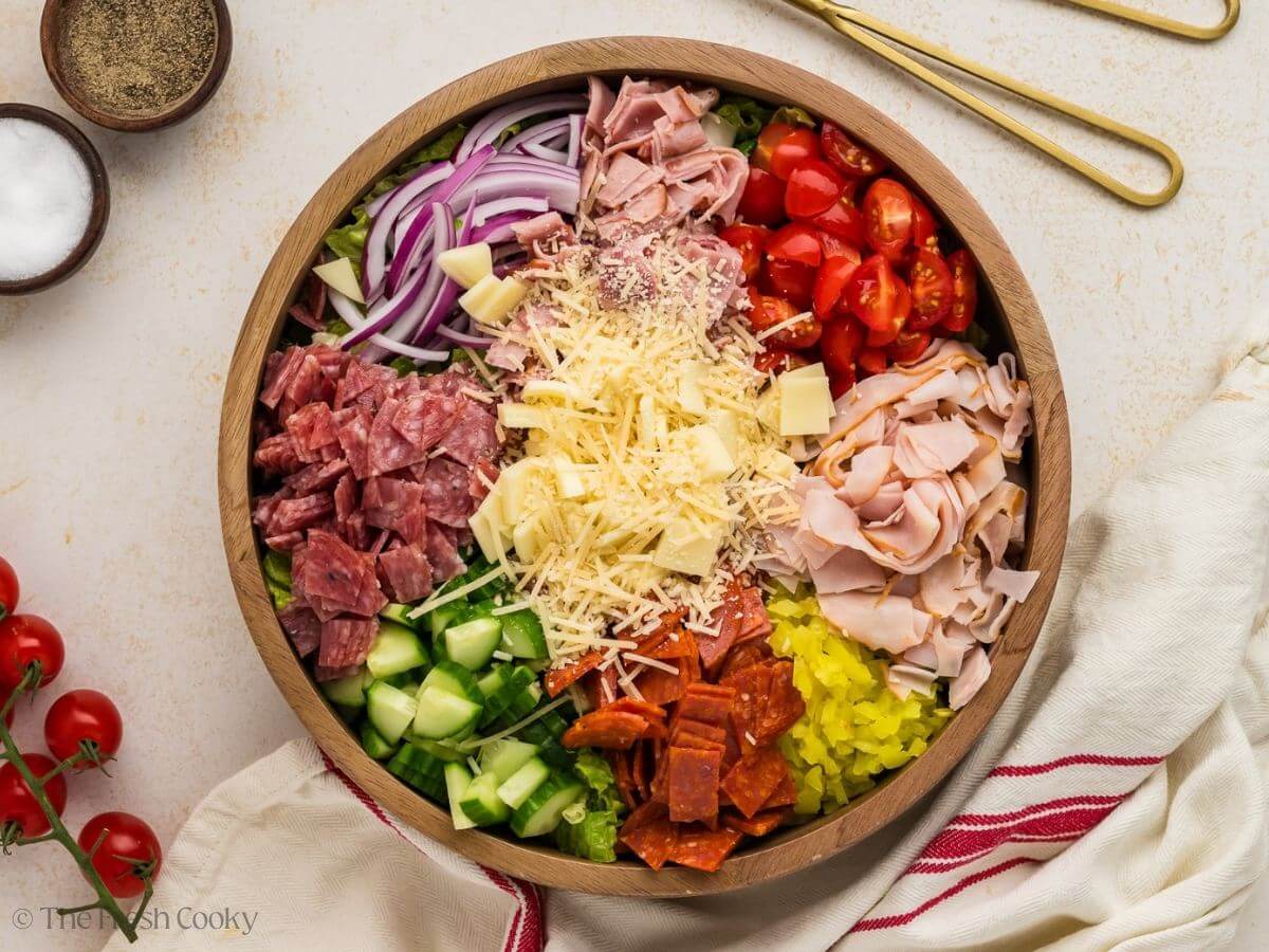 Grinder salad ingredients placed in the salad bowl before being mixed together.
