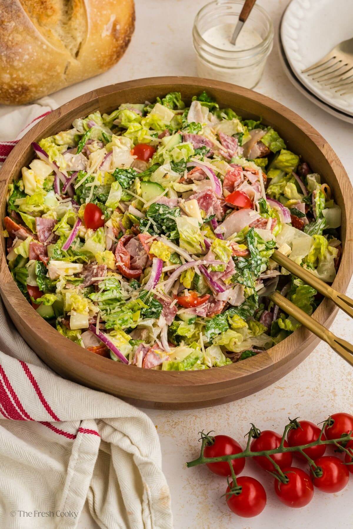 Italian grinder salad in a wooden bowl with salad tongs.
