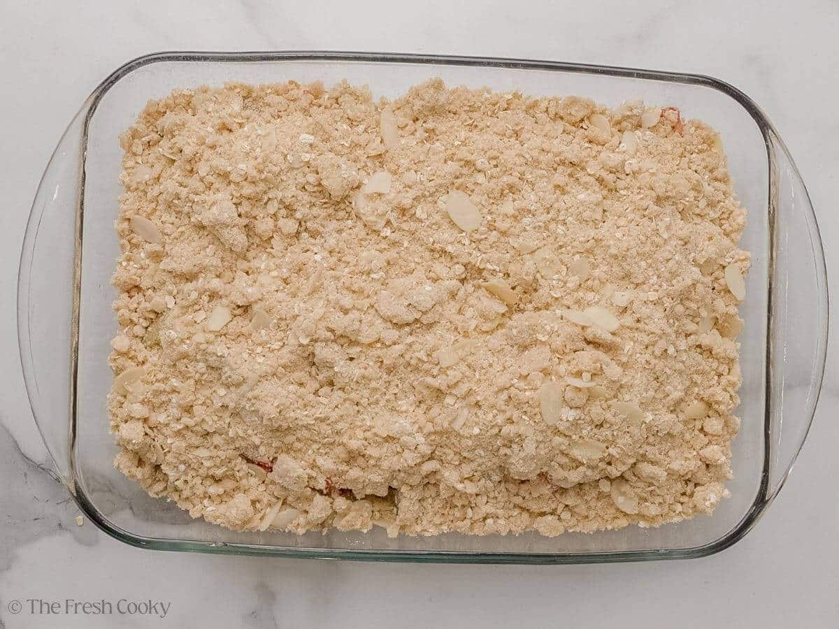 Crisp topping layered on top of the fruit in a baking dish.