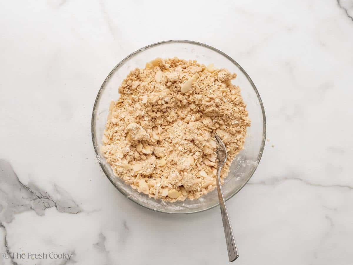 Crisp mixture with everything mixed in, in a glass bowl.