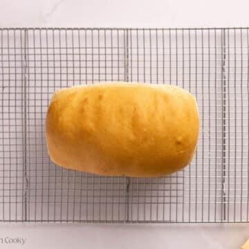 Overhead shot of baked sandwich bread resting on a wire rack.