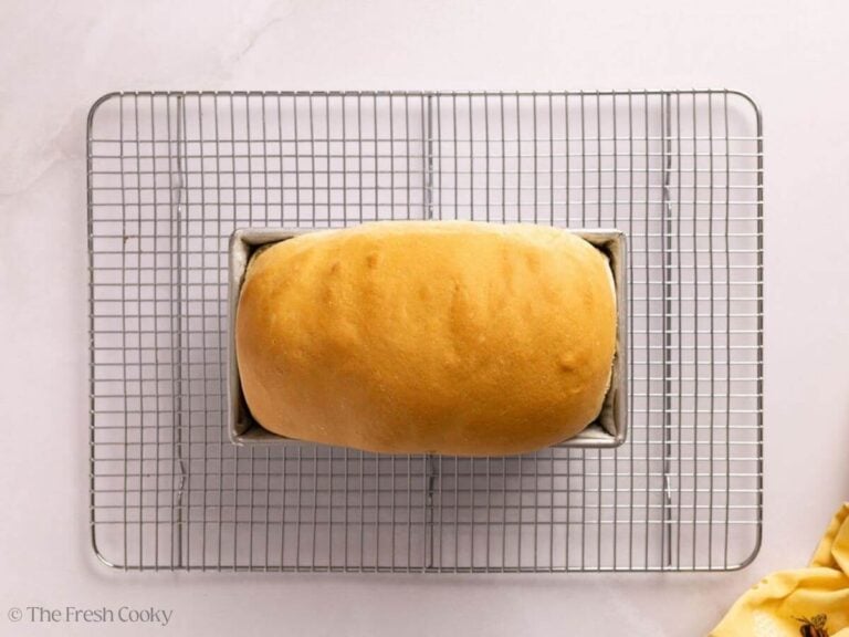 Baked white sandwich bread in a loaf pan.