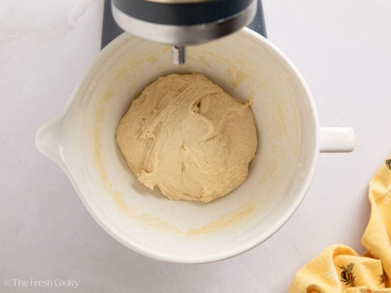 White sandwich dough after mixing in a white stand mixer bowl.