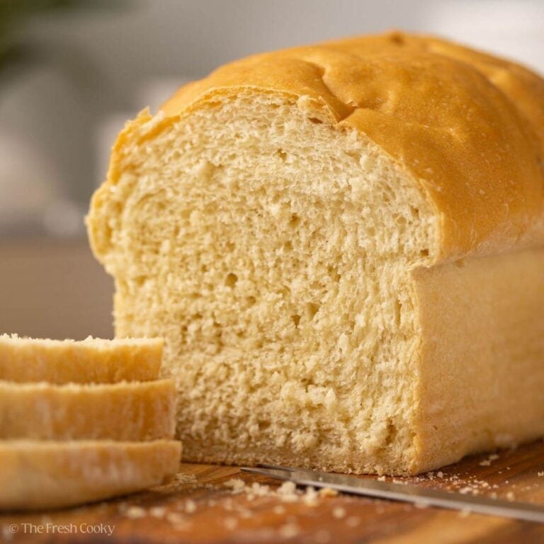 White sandwich bread on a wooden board with some slices taken off.