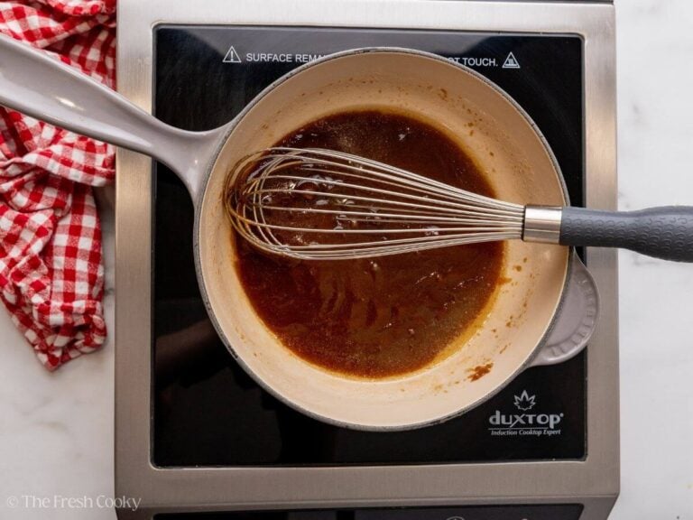 Butter and brown sugar cooking in a skillet with a whisk.