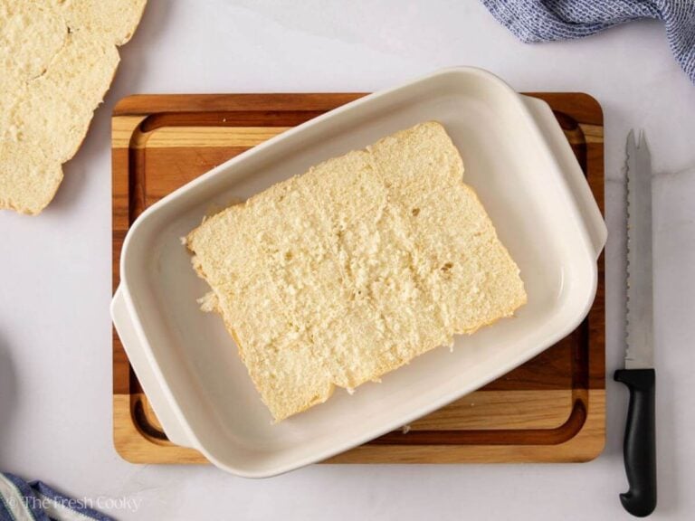 Bottom half of slider rolls placed in a baking dish.
