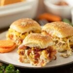 Three chicken bacon sliders on a plate.