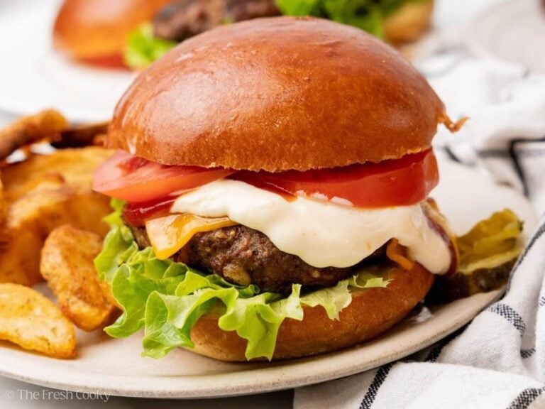 Side view of a homemade burger on a plate.