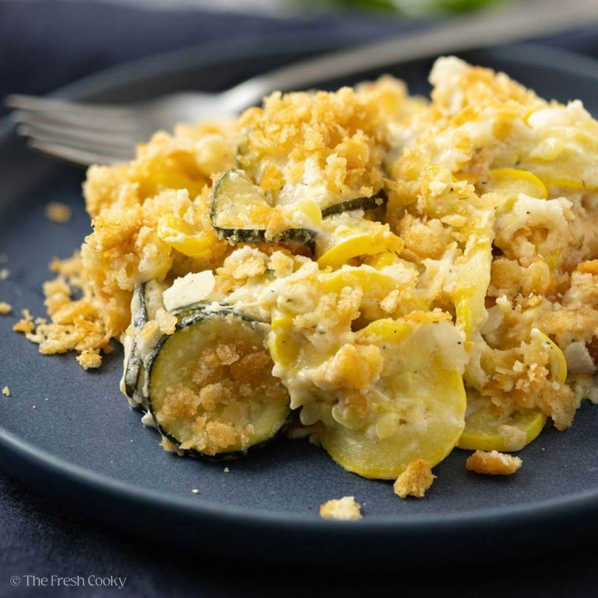 Portion of squash casserole served on a black plate.