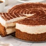 Tiramisu cheesecake with a metal spatula lifting a slices from it.