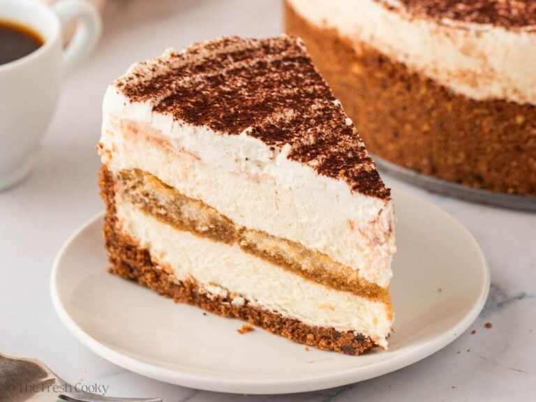 Slice of Tiramisu cheesecake on a white plate.