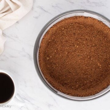 Pressing the graham cracker crust into the springform pan.
