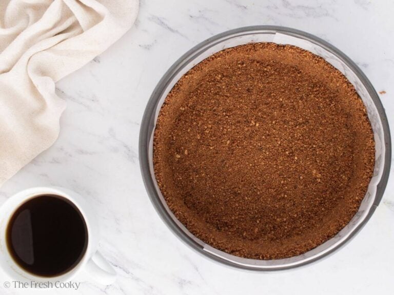 Pressing the graham cracker crust into the springform pan.